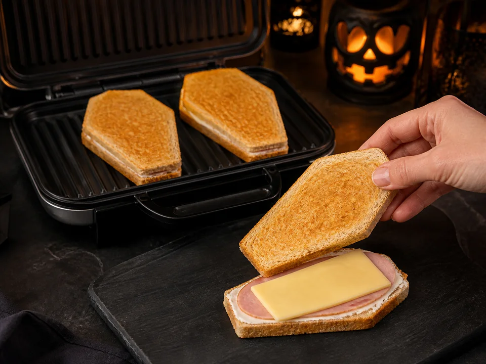 Dünn mit Frischkäse, Schinken und Käse gefüllte Sarg-Sandwiches werden in einem Kontaktgrill goldbraun geröstet